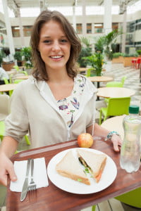 Female student carrying food tray in the cafeteria